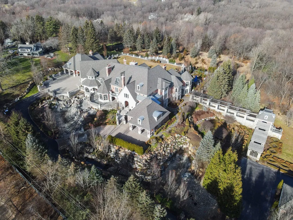 1558 Dutton Road Home in Rochester, Michigan. Discover the epitome of luxury living at this Country Estate in Oakland Township. Spread across 22 acres, the home features hand-carved wooden archways, hand-painted ceiling frescos, and hand-cut stone and gold-leafed accents.