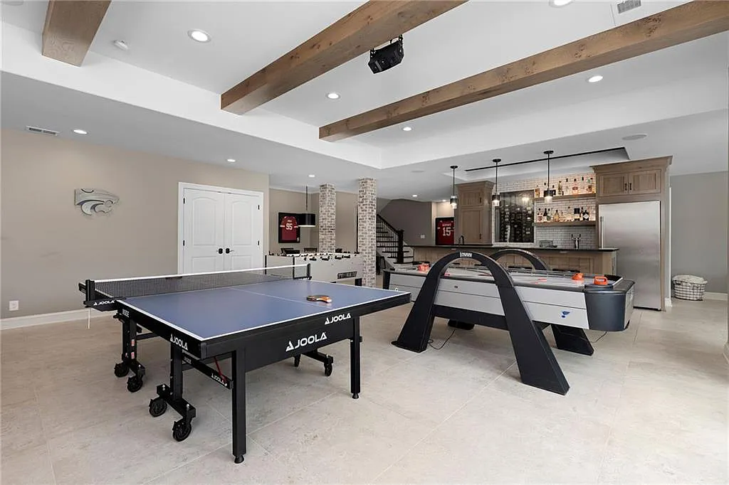 15905 Cody Street Home in Overland Park, Kansas. Step into the world of luxury with this custom-built Holthaus estate featuring magazine-worthy interiors and extensive upgrades. From arched doorways to wide plank rough sawn wood floors, every detail exudes beauty and practicality. Enjoy generous room sizes, beamed ceilings, and designer finishes throughout the 9,000+ square feet of living space. 