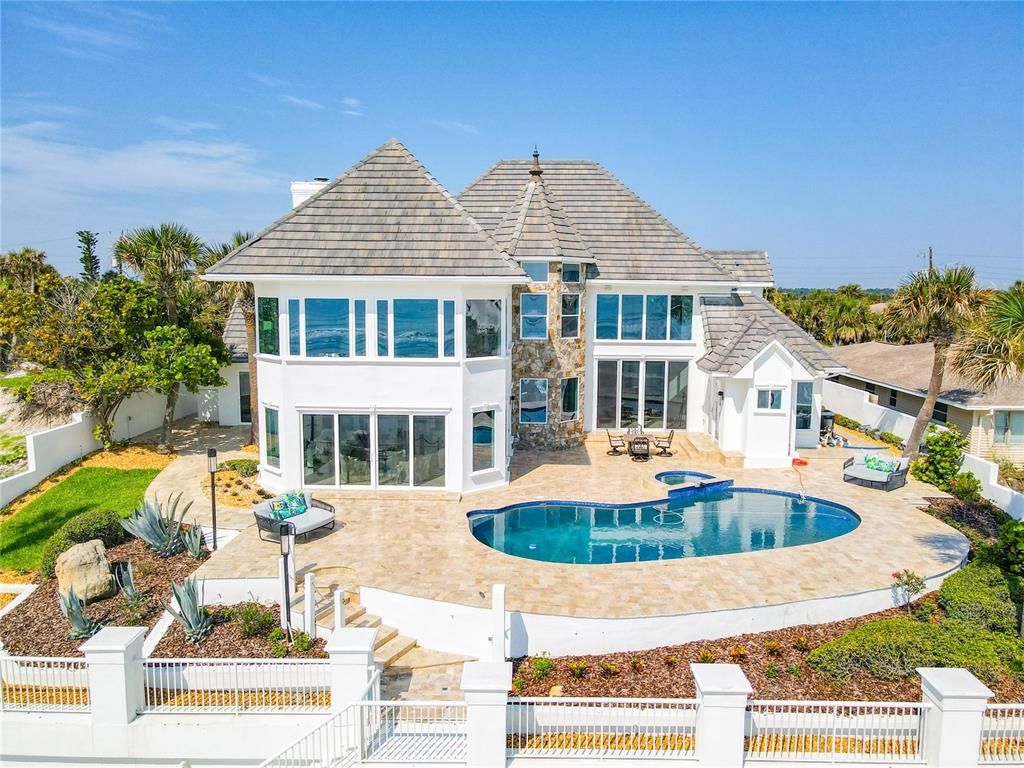 Welcome to 4031 S Atlantic Avenue in Port Orange, Florida - an exquisite beachfront property boasting breathtaking ocean views and a fully renovated design. This gated home offers over 5,300 square feet of living space, featuring 6 bedrooms, 5.5 bathrooms, and an attached in-law suite.