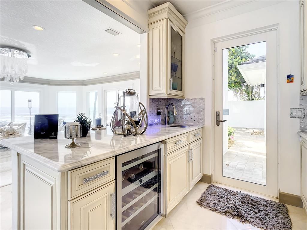 Welcome to 4031 S Atlantic Avenue in Port Orange, Florida - an exquisite beachfront property boasting breathtaking ocean views and a fully renovated design. This gated home offers over 5,300 square feet of living space, featuring 6 bedrooms, 5.5 bathrooms, and an attached in-law suite.