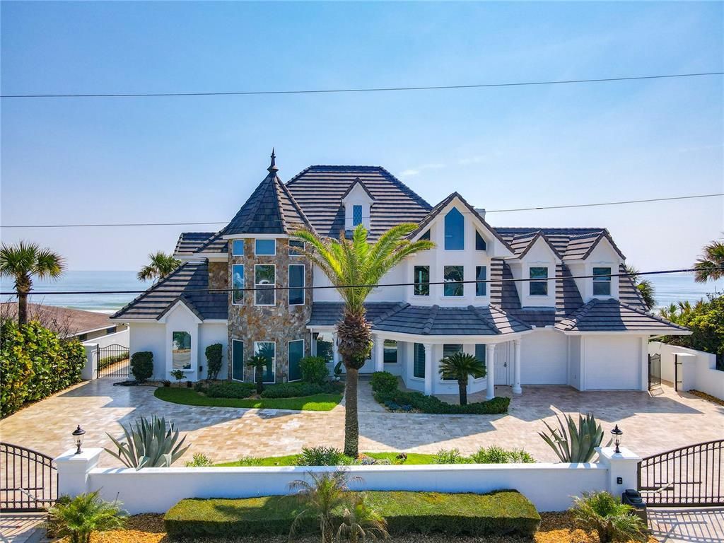 Welcome to 4031 S Atlantic Avenue in Port Orange, Florida - an exquisite beachfront property boasting breathtaking ocean views and a fully renovated design. This gated home offers over 5,300 square feet of living space, featuring 6 bedrooms, 5.5 bathrooms, and an attached in-law suite.