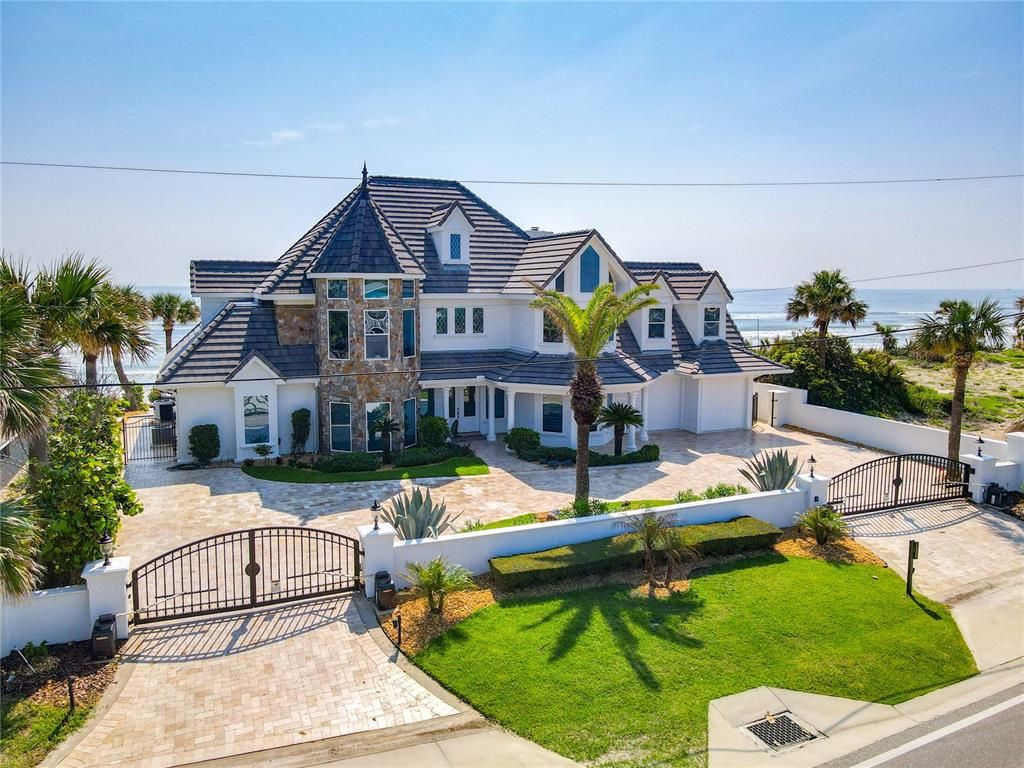 Welcome to 4031 S Atlantic Avenue in Port Orange, Florida - an exquisite beachfront property boasting breathtaking ocean views and a fully renovated design. This gated home offers over 5,300 square feet of living space, featuring 6 bedrooms, 5.5 bathrooms, and an attached in-law suite.