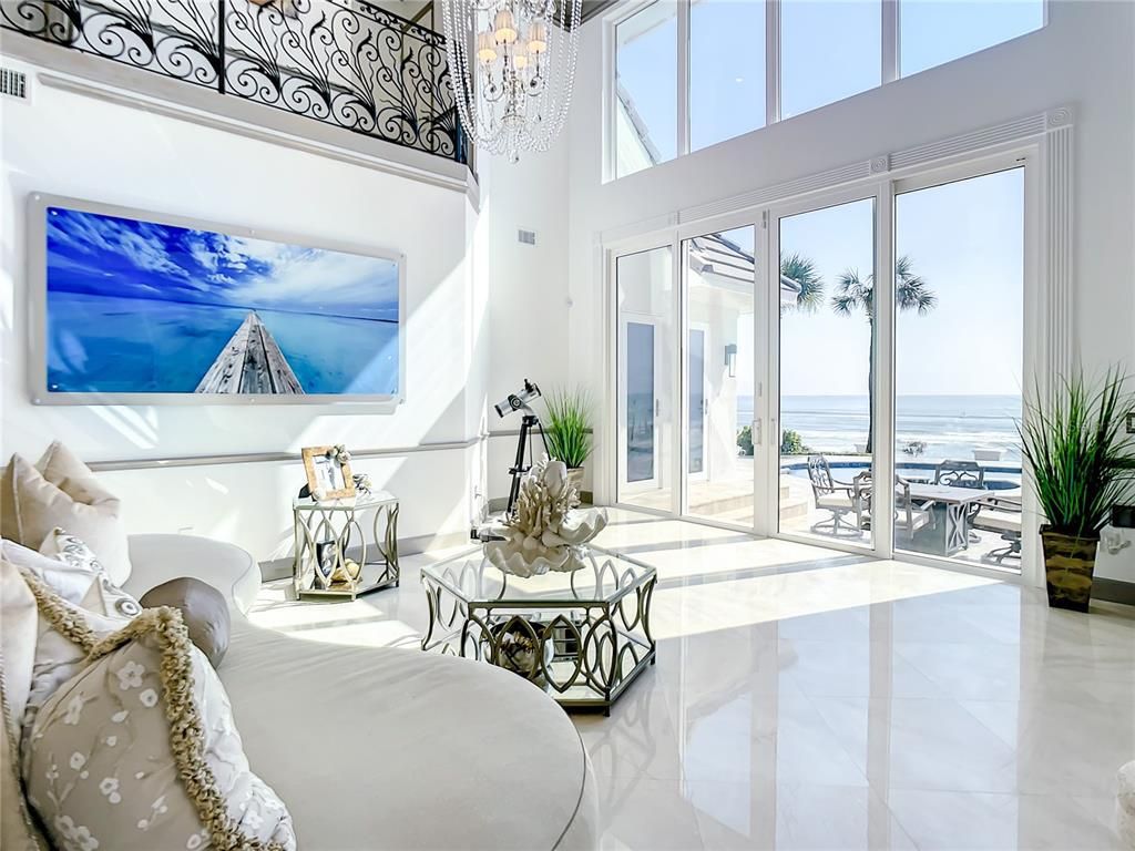 Welcome to 4031 S Atlantic Avenue in Port Orange, Florida - an exquisite beachfront property boasting breathtaking ocean views and a fully renovated design. This gated home offers over 5,300 square feet of living space, featuring 6 bedrooms, 5.5 bathrooms, and an attached in-law suite.