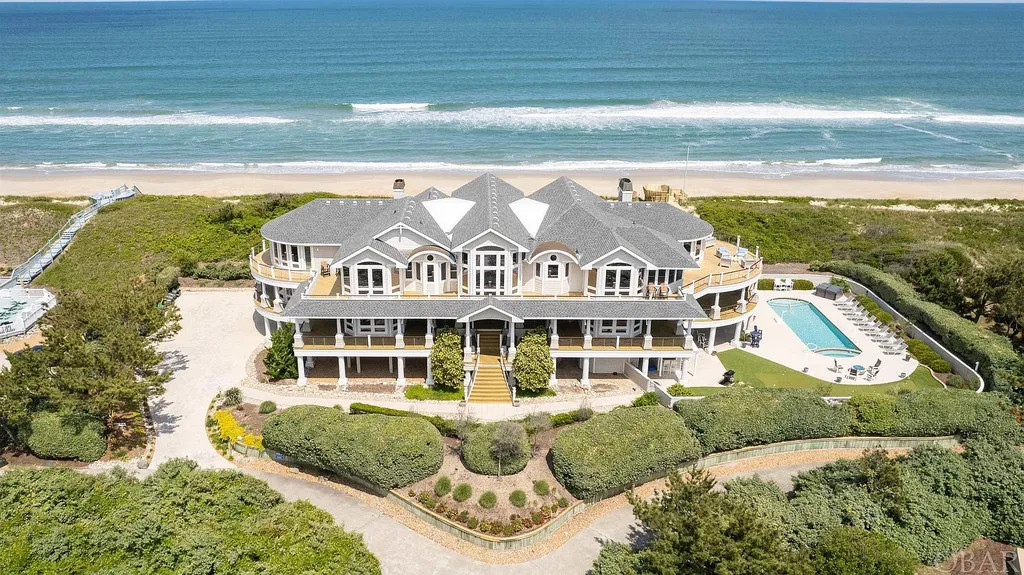 101 Station One Lane Home in Corolla, North Carolina. Discover a remarkable beachfront home with panoramic water views in the prestigious community of Pine Island, Corolla. This stunning coastal retreat offers nine bedrooms with en-suite bathrooms, generous indoor and outdoor amenities, and direct access to 250 feet of secluded beach. 