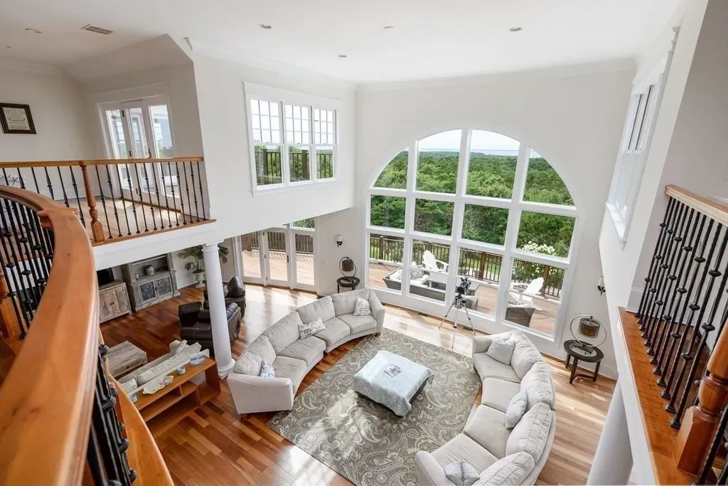 102 Highwood Lane Home in East Falmouth, Massachusetts. Discover unparalleled luxury in Cape Cod's prestigious golf community with this sprawling 10,000-square-foot estate. Perched atop one of Falmouth's highest points, this stunning property offers breathtaking views of Buzzards Bay. Impeccable craftsmanship, elegant design, and high-end finishes define this three-story masterpiece.