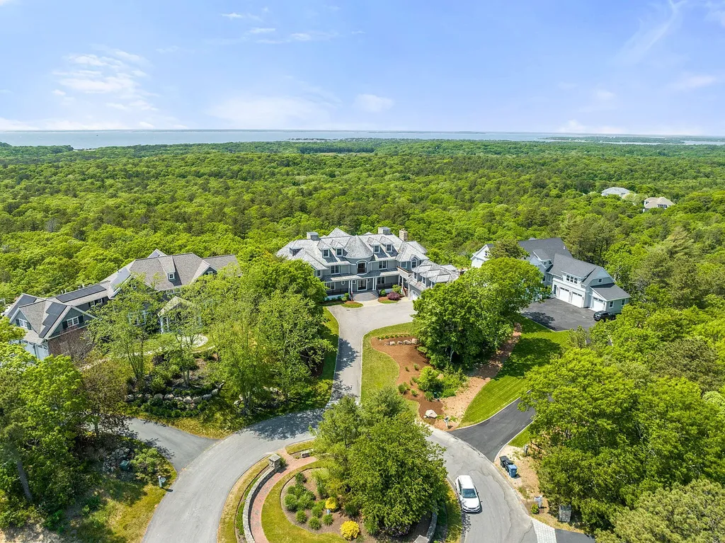 102 Highwood Lane Home in East Falmouth, Massachusetts. Discover unparalleled luxury in Cape Cod's prestigious golf community with this sprawling 10,000-square-foot estate. Perched atop one of Falmouth's highest points, this stunning property offers breathtaking views of Buzzards Bay. Impeccable craftsmanship, elegant design, and high-end finishes define this three-story masterpiece.
