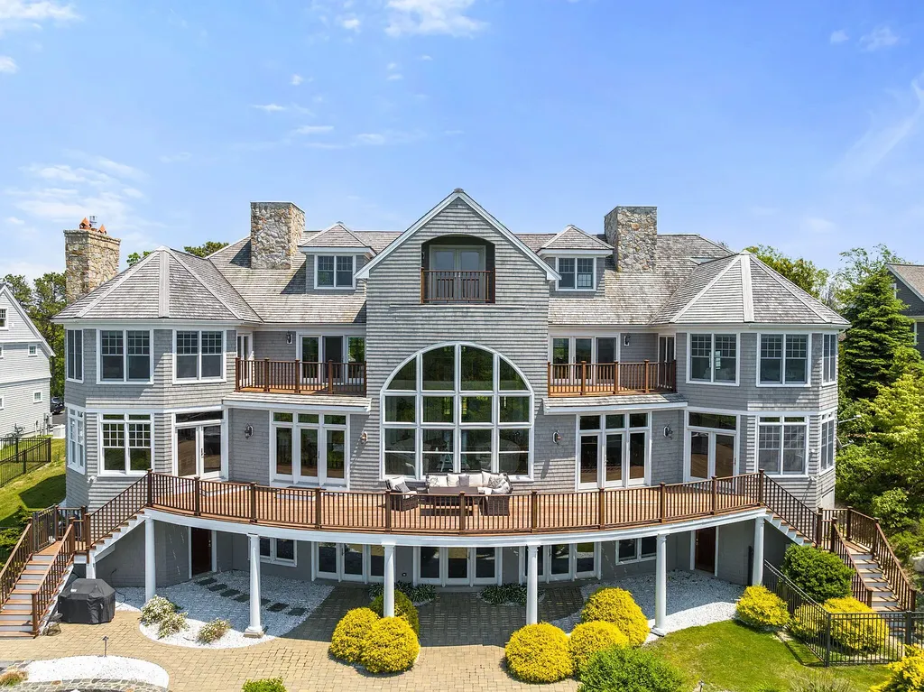 102 Highwood Lane Home in East Falmouth, Massachusetts. Discover unparalleled luxury in Cape Cod's prestigious golf community with this sprawling 10,000-square-foot estate. Perched atop one of Falmouth's highest points, this stunning property offers breathtaking views of Buzzards Bay. Impeccable craftsmanship, elegant design, and high-end finishes define this three-story masterpiece.