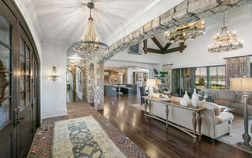 10416 Leonidas Meadow Way Home in Knoxville, Tennessee. Experience the epitome of lakeside luxury in the prestigious West Knoxville enclave of Arcadia. Nestled within this exclusive community, this opulent estate stretches across more than 2.5 acres of prime lakefront property, offering an astonishing 13,000 square feet of meticulously crafted living space. With custom millwork and intricate stonework adorning every corner, this slate and stone residence was artfully constructed with lavishness in mind.