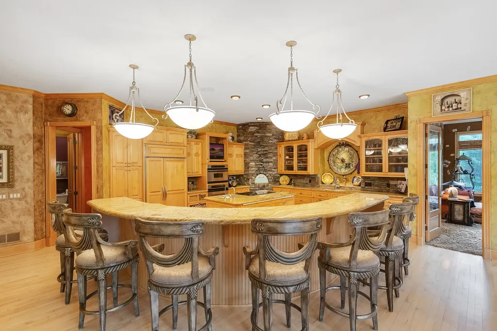 11343 Entrevaux Drive Home in Eden Prairie, Minnesota. Discover the epitome of luxury living in this custom-built Wooddale home, nestled on a serene lot with an extraordinary backyard oasis. The resort-style concrete pool, hot tub, waterfalls, expansive deck, and pergola with a fireplace create an entertainer's dream.