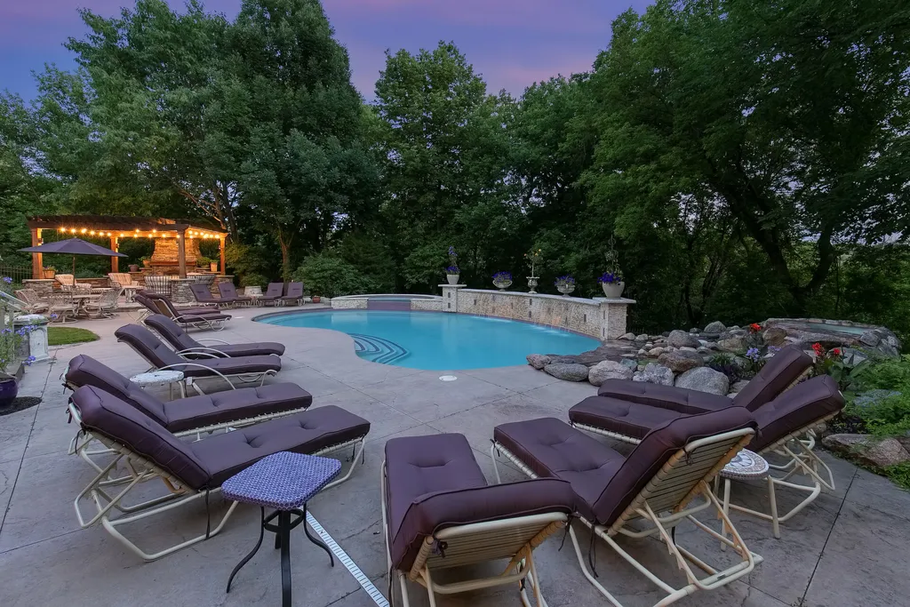 11343 Entrevaux Drive Home in Eden Prairie, Minnesota. Discover the epitome of luxury living in this custom-built Wooddale home, nestled on a serene lot with an extraordinary backyard oasis. The resort-style concrete pool, hot tub, waterfalls, expansive deck, and pergola with a fireplace create an entertainer's dream.