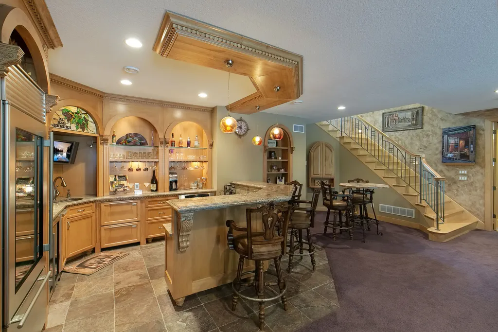 11343 Entrevaux Drive Home in Eden Prairie, Minnesota. Discover the epitome of luxury living in this custom-built Wooddale home, nestled on a serene lot with an extraordinary backyard oasis. The resort-style concrete pool, hot tub, waterfalls, expansive deck, and pergola with a fireplace create an entertainer's dream.