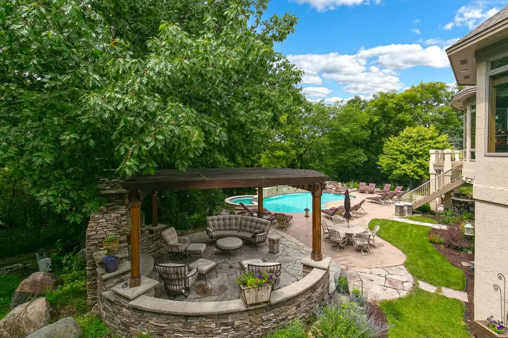 11343 Entrevaux Drive Home in Eden Prairie, Minnesota. Discover the epitome of luxury living in this custom-built Wooddale home, nestled on a serene lot with an extraordinary backyard oasis. The resort-style concrete pool, hot tub, waterfalls, expansive deck, and pergola with a fireplace create an entertainer's dream.