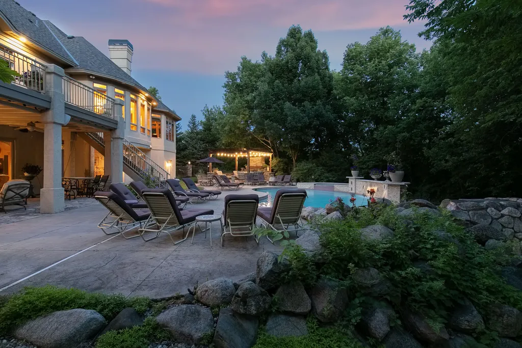 11343 Entrevaux Drive Home in Eden Prairie, Minnesota. Discover the epitome of luxury living in this custom-built Wooddale home, nestled on a serene lot with an extraordinary backyard oasis. The resort-style concrete pool, hot tub, waterfalls, expansive deck, and pergola with a fireplace create an entertainer's dream.