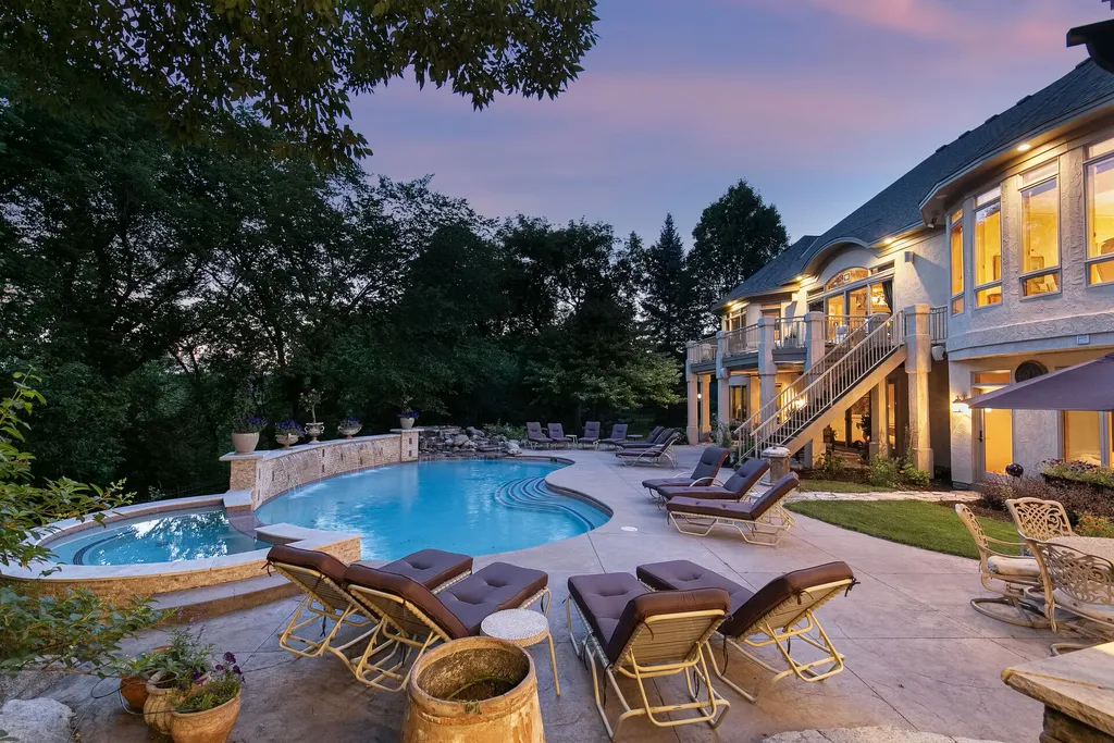 11343 Entrevaux Drive Home in Eden Prairie, Minnesota. Discover the epitome of luxury living in this custom-built Wooddale home, nestled on a serene lot with an extraordinary backyard oasis. The resort-style concrete pool, hot tub, waterfalls, expansive deck, and pergola with a fireplace create an entertainer's dream.