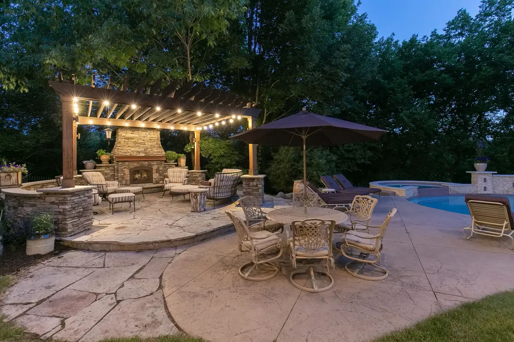 11343 Entrevaux Drive Home in Eden Prairie, Minnesota. Discover the epitome of luxury living in this custom-built Wooddale home, nestled on a serene lot with an extraordinary backyard oasis. The resort-style concrete pool, hot tub, waterfalls, expansive deck, and pergola with a fireplace create an entertainer's dream.