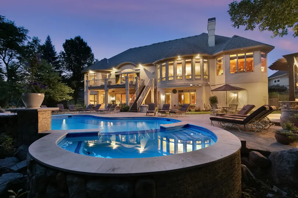 11343 Entrevaux Drive Home in Eden Prairie, Minnesota. Discover the epitome of luxury living in this custom-built Wooddale home, nestled on a serene lot with an extraordinary backyard oasis. The resort-style concrete pool, hot tub, waterfalls, expansive deck, and pergola with a fireplace create an entertainer's dream.