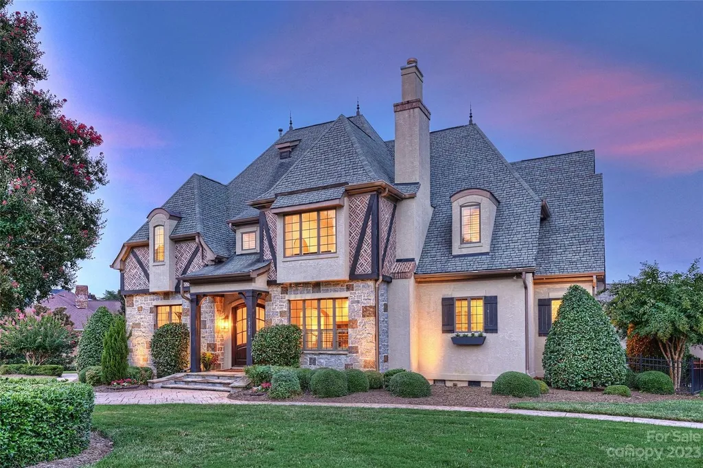 18726 John Connor Road Home in Cornelius, North Carolina. Discover a French-Tudor masterpiece where classic elegance harmoniously merges with contemporary comfort. This estate presents an enchanting façade with steep roofs, tall windows, and intricate wrought iron accents that embody ageless allure.