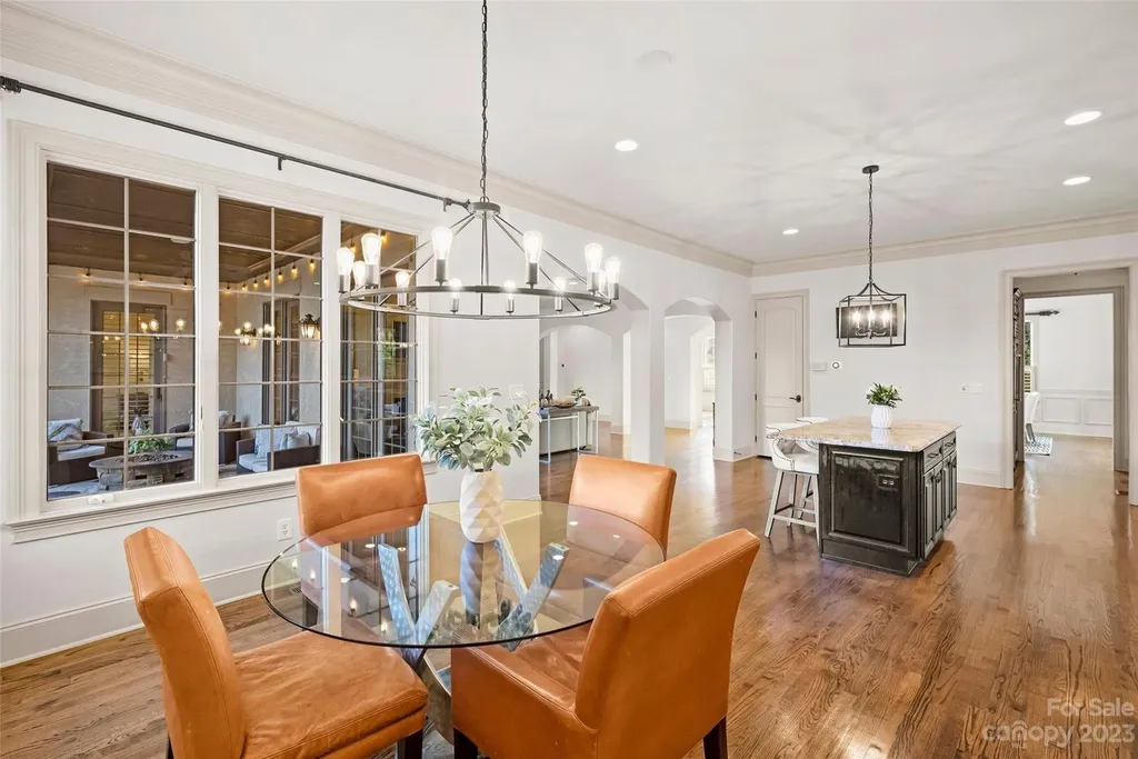18726 John Connor Road Home in Cornelius, North Carolina. Discover a French-Tudor masterpiece where classic elegance harmoniously merges with contemporary comfort. This estate presents an enchanting façade with steep roofs, tall windows, and intricate wrought iron accents that embody ageless allure.
