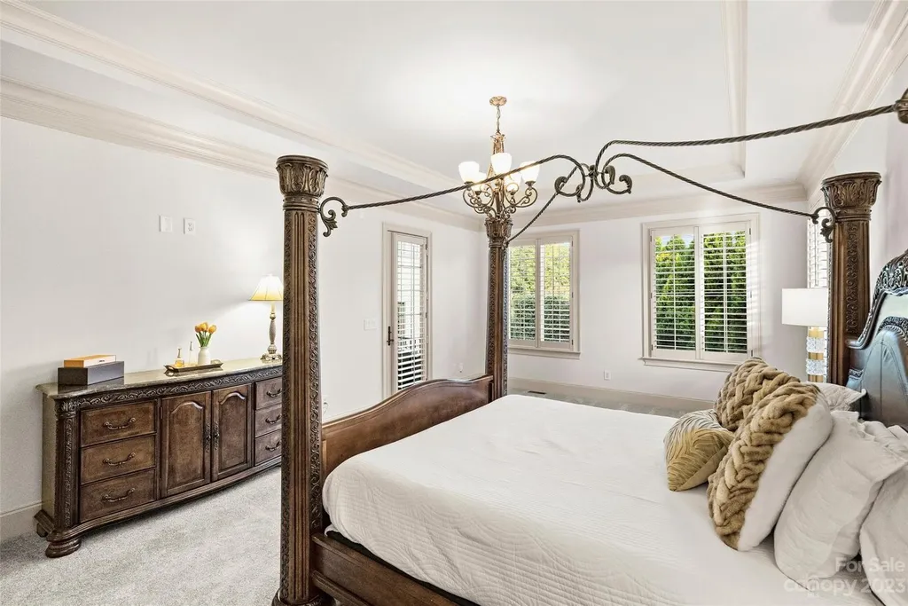 18726 John Connor Road Home in Cornelius, North Carolina. Discover a French-Tudor masterpiece where classic elegance harmoniously merges with contemporary comfort. This estate presents an enchanting façade with steep roofs, tall windows, and intricate wrought iron accents that embody ageless allure.