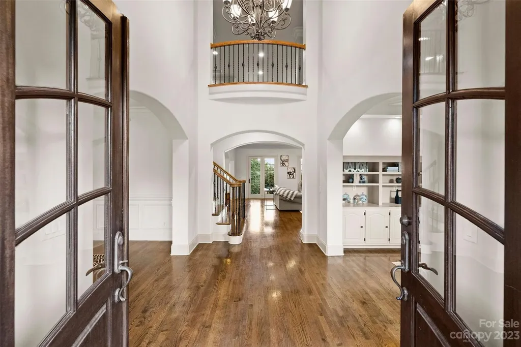 18726 John Connor Road Home in Cornelius, North Carolina. Discover a French-Tudor masterpiece where classic elegance harmoniously merges with contemporary comfort. This estate presents an enchanting façade with steep roofs, tall windows, and intricate wrought iron accents that embody ageless allure.