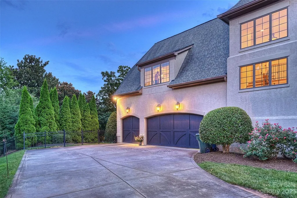 18726 John Connor Road Home in Cornelius, North Carolina. Discover a French-Tudor masterpiece where classic elegance harmoniously merges with contemporary comfort. This estate presents an enchanting façade with steep roofs, tall windows, and intricate wrought iron accents that embody ageless allure.