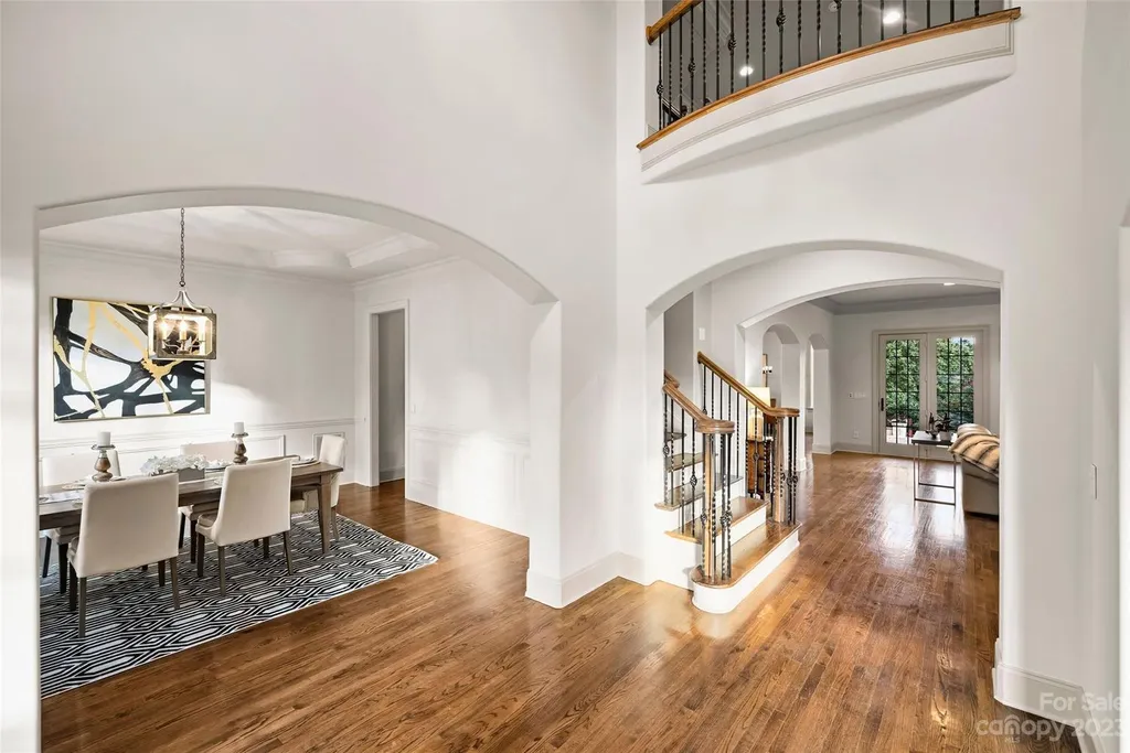18726 John Connor Road Home in Cornelius, North Carolina. Discover a French-Tudor masterpiece where classic elegance harmoniously merges with contemporary comfort. This estate presents an enchanting façade with steep roofs, tall windows, and intricate wrought iron accents that embody ageless allure.