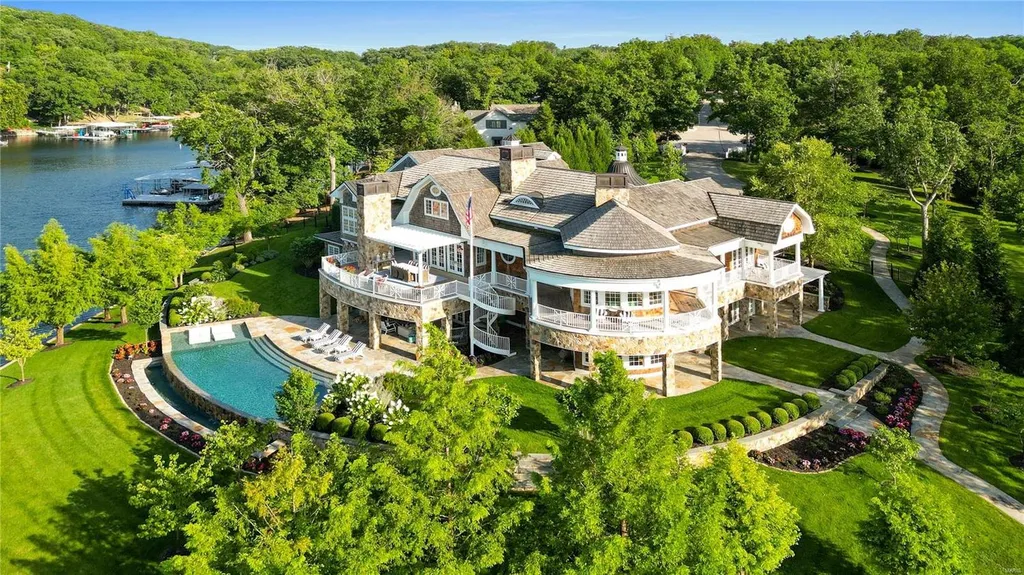 282 Timber Ridge Lane Home in Lake Ozark, Missouri. "Nantucket Point" is the ultimate Crown Jewel of Lake of The Ozarks, offering 1.24 acres of unparalleled beauty with 500' of shoreline, deep water, and breathtaking views. This Nantucket-inspired 6,800 sqft estate exudes laid-back luxury and coastal design, featuring 6 ensuite bedrooms, 2 gourmet kitchens, a gym, game room, and more. 