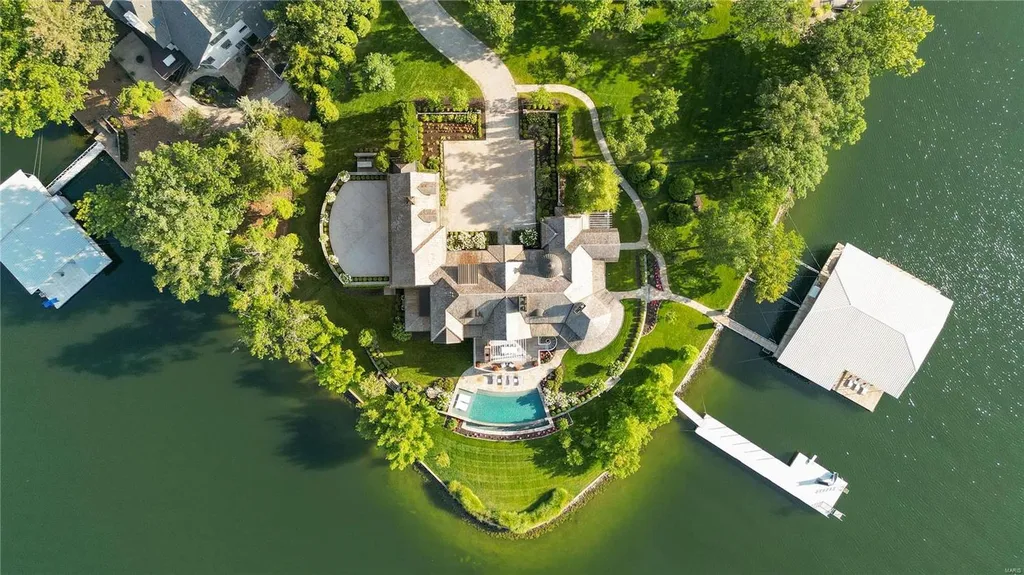 282 Timber Ridge Lane Home in Lake Ozark, Missouri. "Nantucket Point" is the ultimate Crown Jewel of Lake of The Ozarks, offering 1.24 acres of unparalleled beauty with 500' of shoreline, deep water, and breathtaking views. This Nantucket-inspired 6,800 sqft estate exudes laid-back luxury and coastal design, featuring 6 ensuite bedrooms, 2 gourmet kitchens, a gym, game room, and more. 