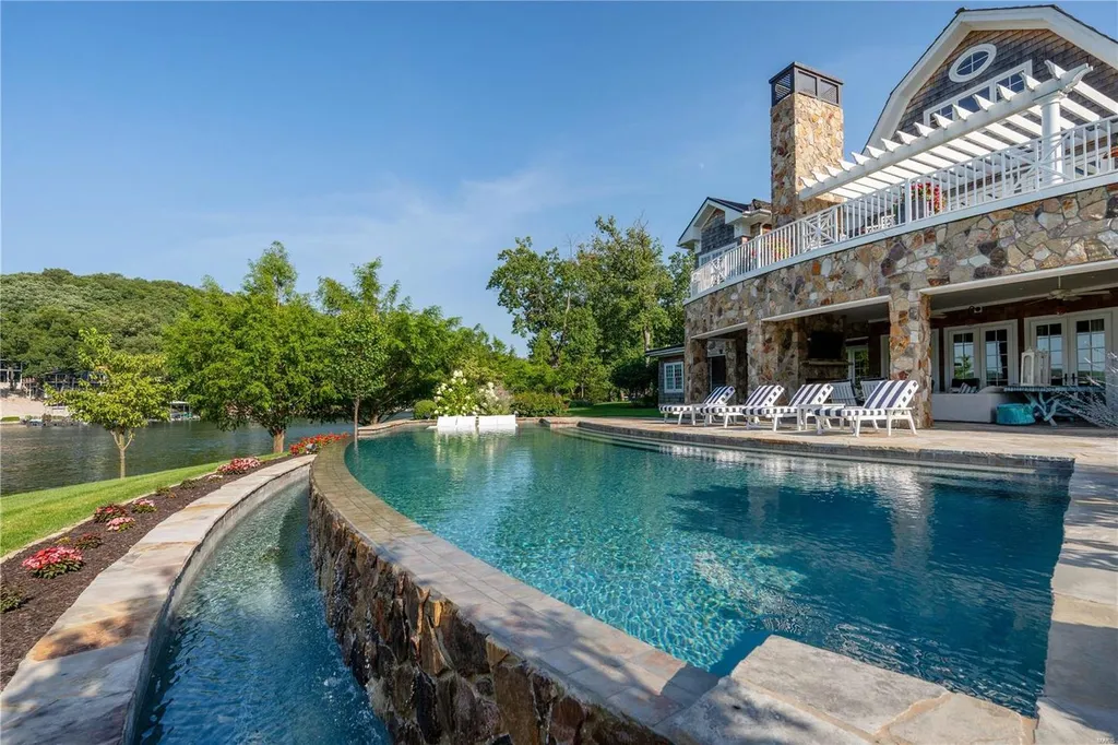 282 Timber Ridge Lane Home in Lake Ozark, Missouri. "Nantucket Point" is the ultimate Crown Jewel of Lake of The Ozarks, offering 1.24 acres of unparalleled beauty with 500' of shoreline, deep water, and breathtaking views. This Nantucket-inspired 6,800 sqft estate exudes laid-back luxury and coastal design, featuring 6 ensuite bedrooms, 2 gourmet kitchens, a gym, game room, and more. 