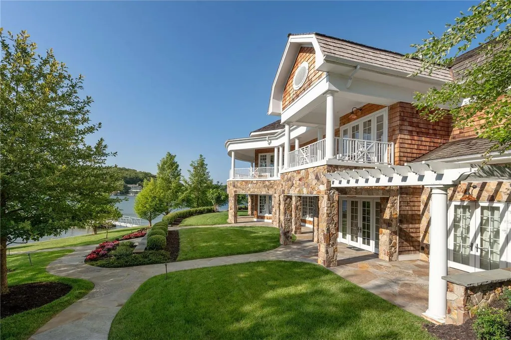 282 Timber Ridge Lane Home in Lake Ozark, Missouri. "Nantucket Point" is the ultimate Crown Jewel of Lake of The Ozarks, offering 1.24 acres of unparalleled beauty with 500' of shoreline, deep water, and breathtaking views. This Nantucket-inspired 6,800 sqft estate exudes laid-back luxury and coastal design, featuring 6 ensuite bedrooms, 2 gourmet kitchens, a gym, game room, and more. 