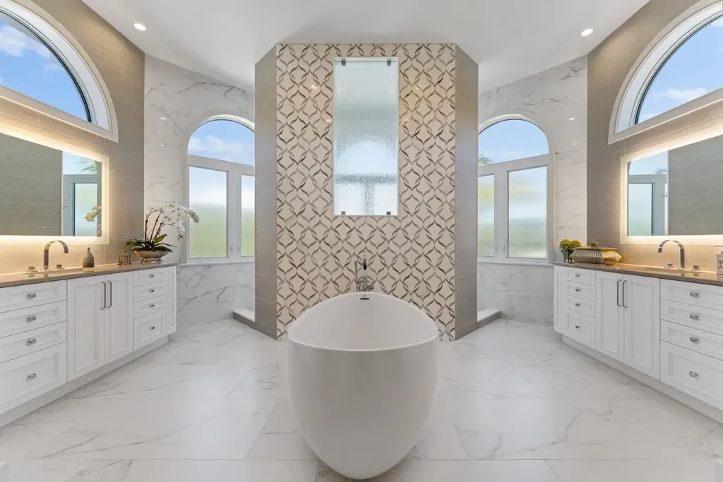 3057 SE Dune Drive Home in Stuart, Florida. Discover this artfully reimagined and fully renovated home boasting panoramic views of a Jack Nicklaus golf course, the lake, and the ocean. Flooded with natural light through 166 windows, the neutral palette accentuates exquisite finishes and architectural details. 