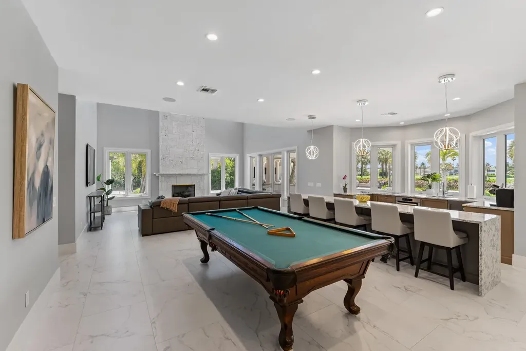 3057 SE Dune Drive Home in Stuart, Florida. Discover this artfully reimagined and fully renovated home boasting panoramic views of a Jack Nicklaus golf course, the lake, and the ocean. Flooded with natural light through 166 windows, the neutral palette accentuates exquisite finishes and architectural details. 