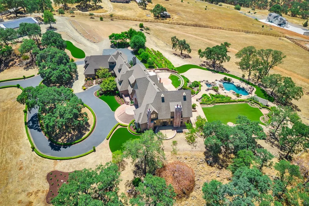 4160 Marble Ridge Road Home in El Dorado Hills, California. Discover the extraordinary 10-acre hilltop estate offering breathtaking views and a resort-like experience. This stately home features massive floor-to-ceiling windows, an elegant living room with a full bar, and a modern great room with a gourmet kitchen.
