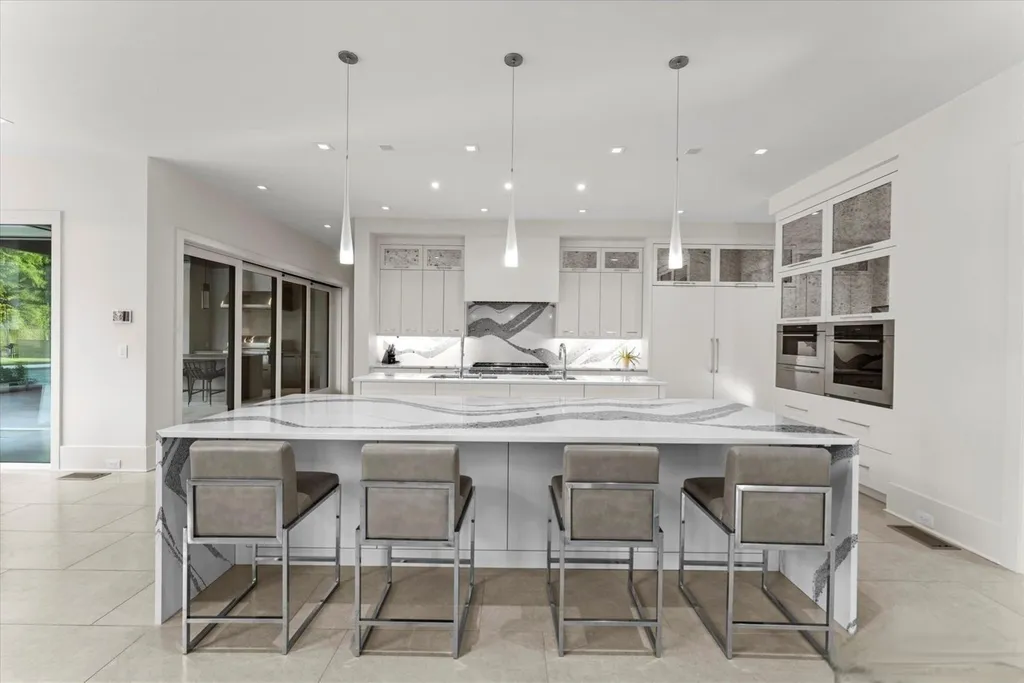 519 Brackenbury Lane Home in Charlotte, North Carolina. Discover a truly unique modern Kingswood Home built in 2019, an exquisite and meticulously designed residence that showcases the epitome of luxury living. With 7,491 square feet spread over 2 acres, this home boasts a custom curved stairwell by Artisan, a stunning glass refrigerated wine display room, and Walker Zanger light gray stone tile throughout the main and upper levels. 