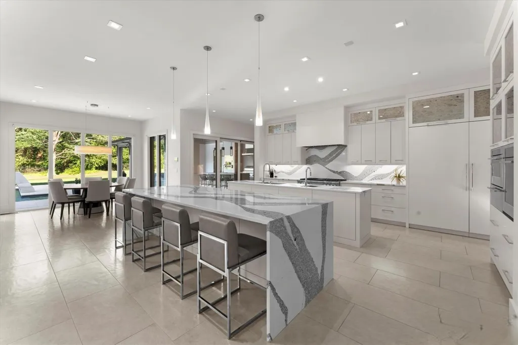 519 Brackenbury Lane Home in Charlotte, North Carolina. Discover a truly unique modern Kingswood Home built in 2019, an exquisite and meticulously designed residence that showcases the epitome of luxury living. With 7,491 square feet spread over 2 acres, this home boasts a custom curved stairwell by Artisan, a stunning glass refrigerated wine display room, and Walker Zanger light gray stone tile throughout the main and upper levels. 