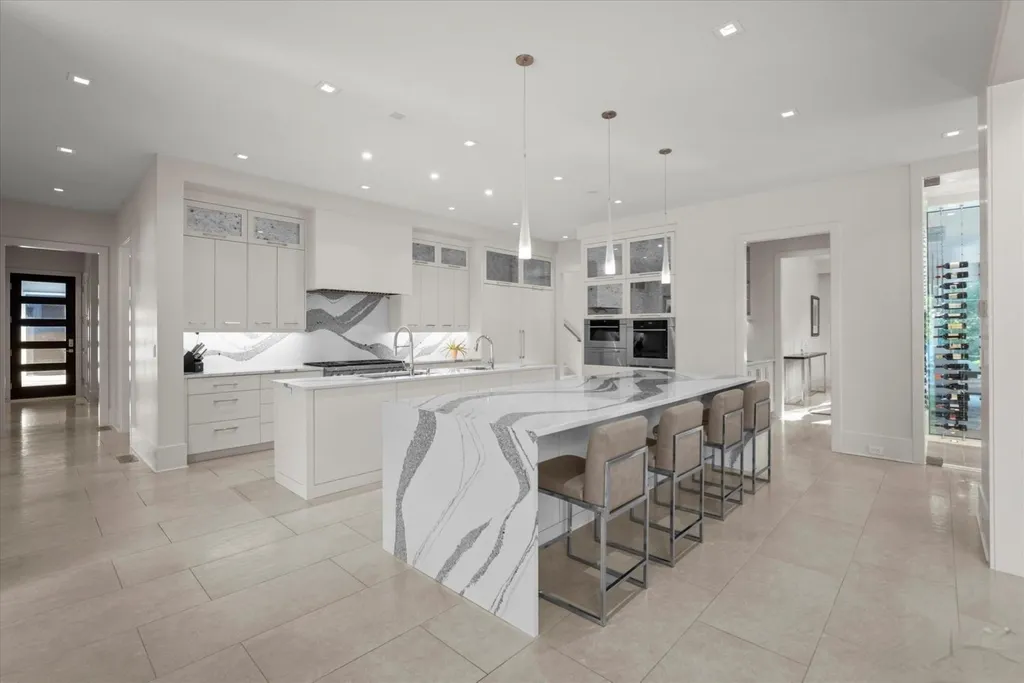 519 Brackenbury Lane Home in Charlotte, North Carolina. Discover a truly unique modern Kingswood Home built in 2019, an exquisite and meticulously designed residence that showcases the epitome of luxury living. With 7,491 square feet spread over 2 acres, this home boasts a custom curved stairwell by Artisan, a stunning glass refrigerated wine display room, and Walker Zanger light gray stone tile throughout the main and upper levels. 