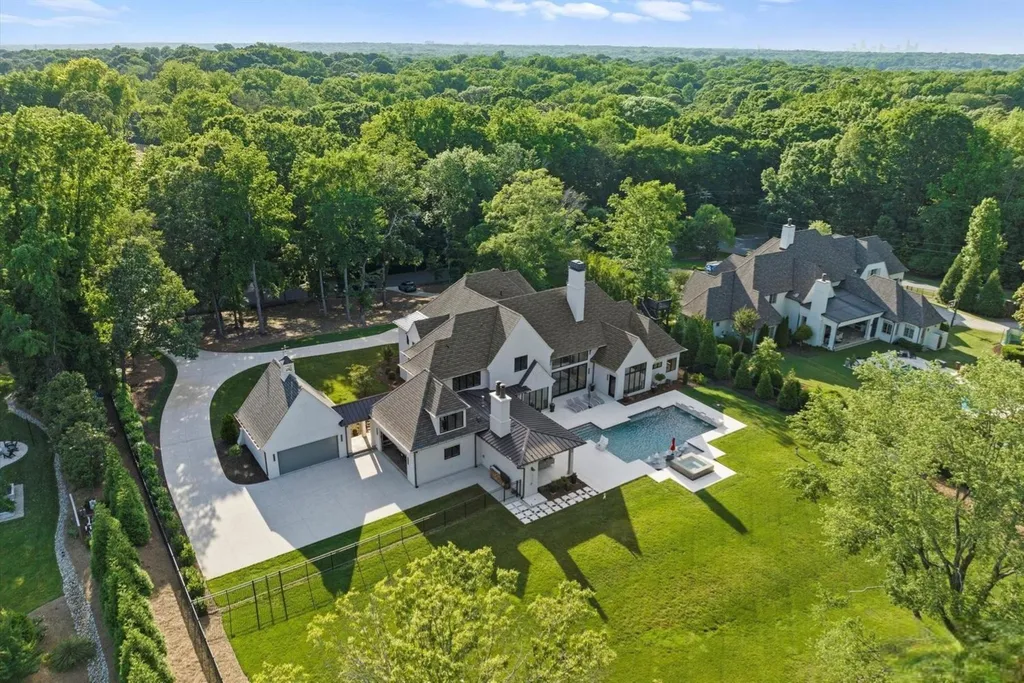 519 Brackenbury Lane Home in Charlotte, North Carolina. Discover a truly unique modern Kingswood Home built in 2019, an exquisite and meticulously designed residence that showcases the epitome of luxury living. With 7,491 square feet spread over 2 acres, this home boasts a custom curved stairwell by Artisan, a stunning glass refrigerated wine display room, and Walker Zanger light gray stone tile throughout the main and upper levels. 