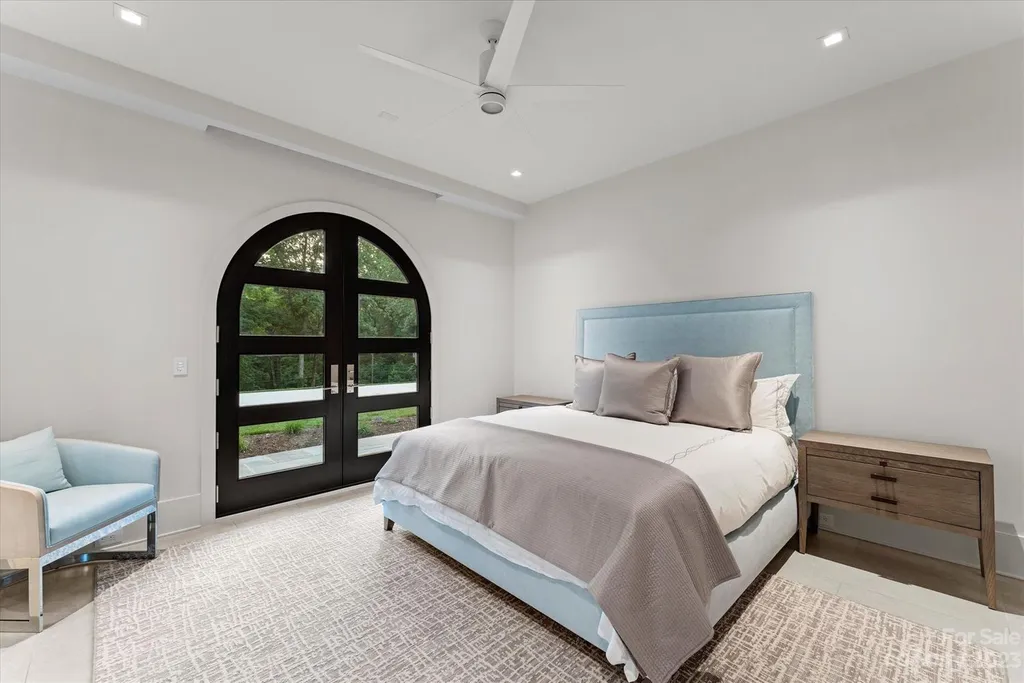 519 Brackenbury Lane Home in Charlotte, North Carolina. Discover a truly unique modern Kingswood Home built in 2019, an exquisite and meticulously designed residence that showcases the epitome of luxury living. With 7,491 square feet spread over 2 acres, this home boasts a custom curved stairwell by Artisan, a stunning glass refrigerated wine display room, and Walker Zanger light gray stone tile throughout the main and upper levels. 
