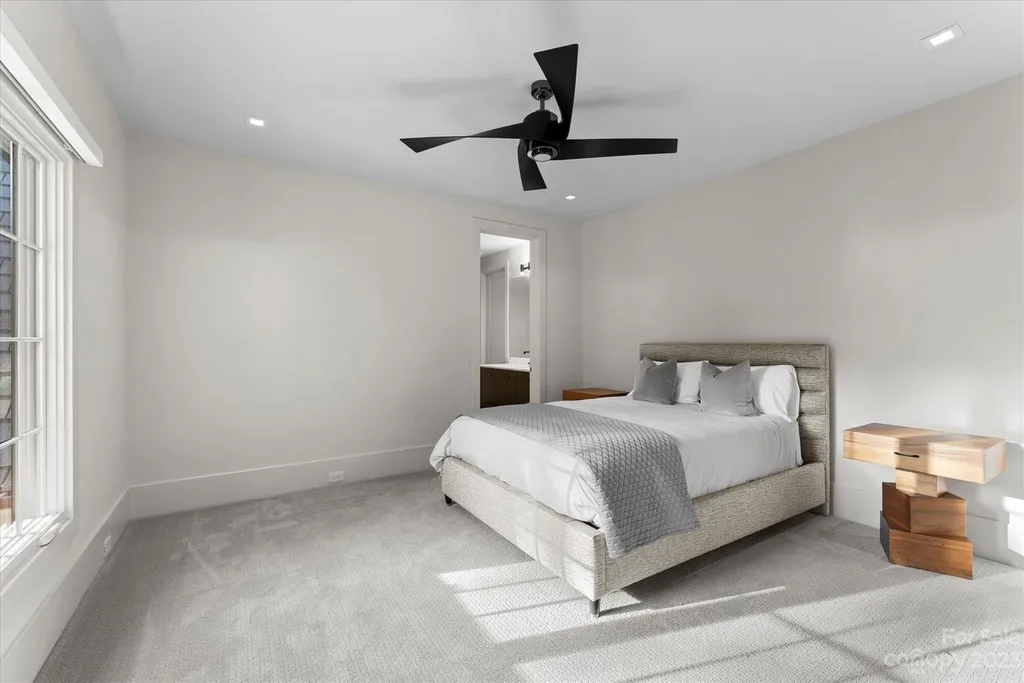 519 Brackenbury Lane Home in Charlotte, North Carolina. Discover a truly unique modern Kingswood Home built in 2019, an exquisite and meticulously designed residence that showcases the epitome of luxury living. With 7,491 square feet spread over 2 acres, this home boasts a custom curved stairwell by Artisan, a stunning glass refrigerated wine display room, and Walker Zanger light gray stone tile throughout the main and upper levels. 
