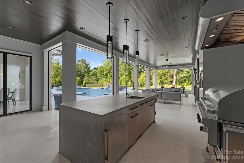 519 Brackenbury Lane Home in Charlotte, North Carolina. Discover a truly unique modern Kingswood Home built in 2019, an exquisite and meticulously designed residence that showcases the epitome of luxury living. With 7,491 square feet spread over 2 acres, this home boasts a custom curved stairwell by Artisan, a stunning glass refrigerated wine display room, and Walker Zanger light gray stone tile throughout the main and upper levels. 