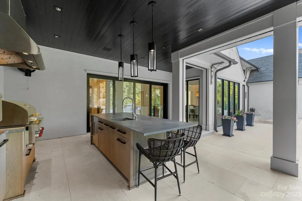 519 Brackenbury Lane Home in Charlotte, North Carolina. Discover a truly unique modern Kingswood Home built in 2019, an exquisite and meticulously designed residence that showcases the epitome of luxury living. With 7,491 square feet spread over 2 acres, this home boasts a custom curved stairwell by Artisan, a stunning glass refrigerated wine display room, and Walker Zanger light gray stone tile throughout the main and upper levels. 
