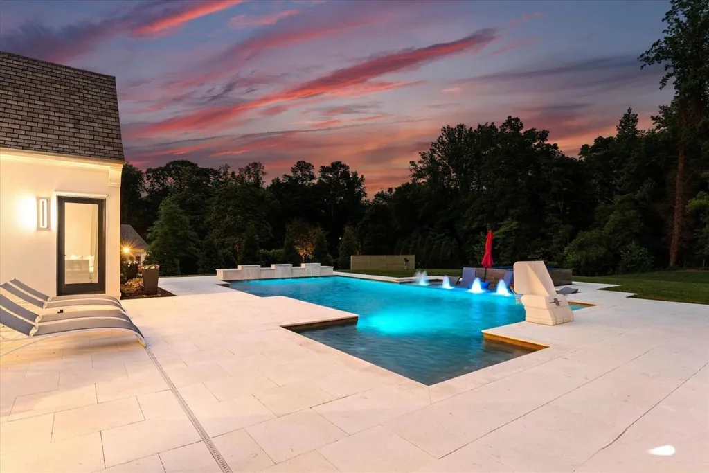 519 Brackenbury Lane Home in Charlotte, North Carolina. Discover a truly unique modern Kingswood Home built in 2019, an exquisite and meticulously designed residence that showcases the epitome of luxury living. With 7,491 square feet spread over 2 acres, this home boasts a custom curved stairwell by Artisan, a stunning glass refrigerated wine display room, and Walker Zanger light gray stone tile throughout the main and upper levels. 