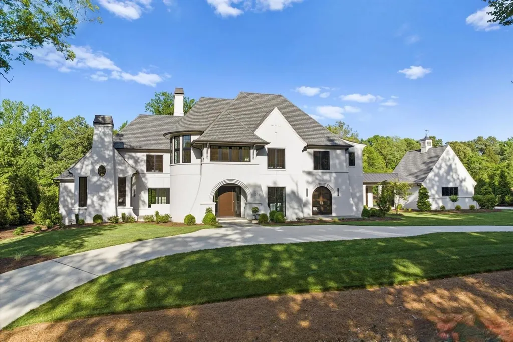 519 Brackenbury Lane Home in Charlotte, North Carolina. Discover a truly unique modern Kingswood Home built in 2019, an exquisite and meticulously designed residence that showcases the epitome of luxury living. With 7,491 square feet spread over 2 acres, this home boasts a custom curved stairwell by Artisan, a stunning glass refrigerated wine display room, and Walker Zanger light gray stone tile throughout the main and upper levels. 