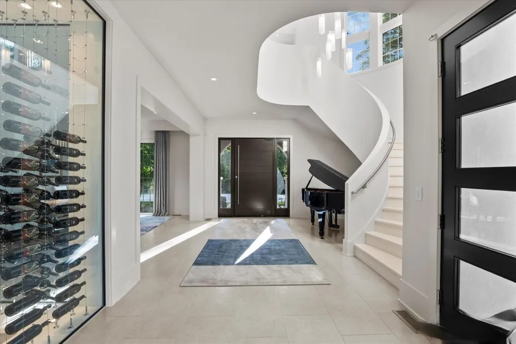 519 Brackenbury Lane Home in Charlotte, North Carolina. Discover a truly unique modern Kingswood Home built in 2019, an exquisite and meticulously designed residence that showcases the epitome of luxury living. With 7,491 square feet spread over 2 acres, this home boasts a custom curved stairwell by Artisan, a stunning glass refrigerated wine display room, and Walker Zanger light gray stone tile throughout the main and upper levels. 