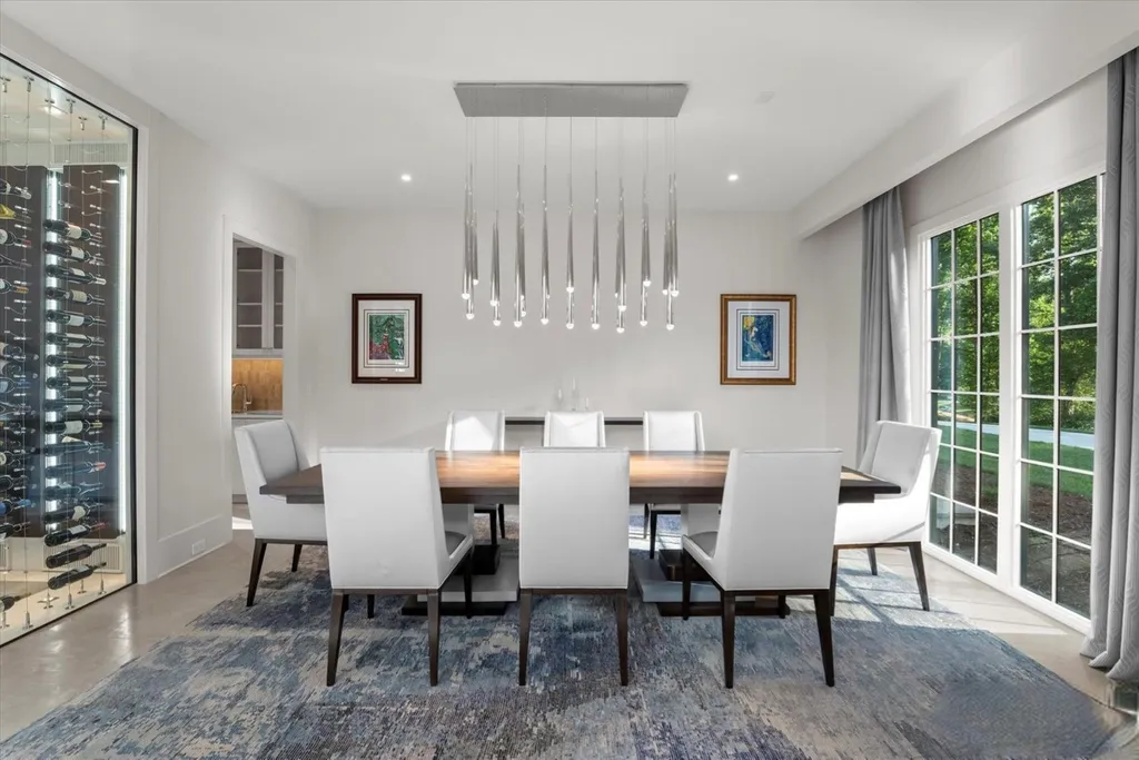 519 Brackenbury Lane Home in Charlotte, North Carolina. Discover a truly unique modern Kingswood Home built in 2019, an exquisite and meticulously designed residence that showcases the epitome of luxury living. With 7,491 square feet spread over 2 acres, this home boasts a custom curved stairwell by Artisan, a stunning glass refrigerated wine display room, and Walker Zanger light gray stone tile throughout the main and upper levels. 