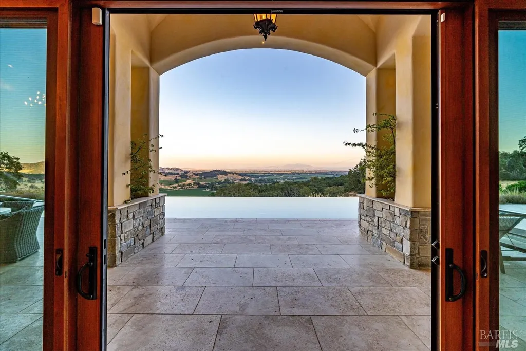 5343-5355 Suisun Valley Road Home in Fairfield, California. Stunning 20-acre hilltop compound in Fairfield boasts panoramic views of the valley, vineyards, and Mount Diablo. The Tuscan-inspired main house features cathedral ceilings, antique beams, and travertine flooring. The majestic living/dining great room has a fireplace and overlooks the pool, patio, and views. 