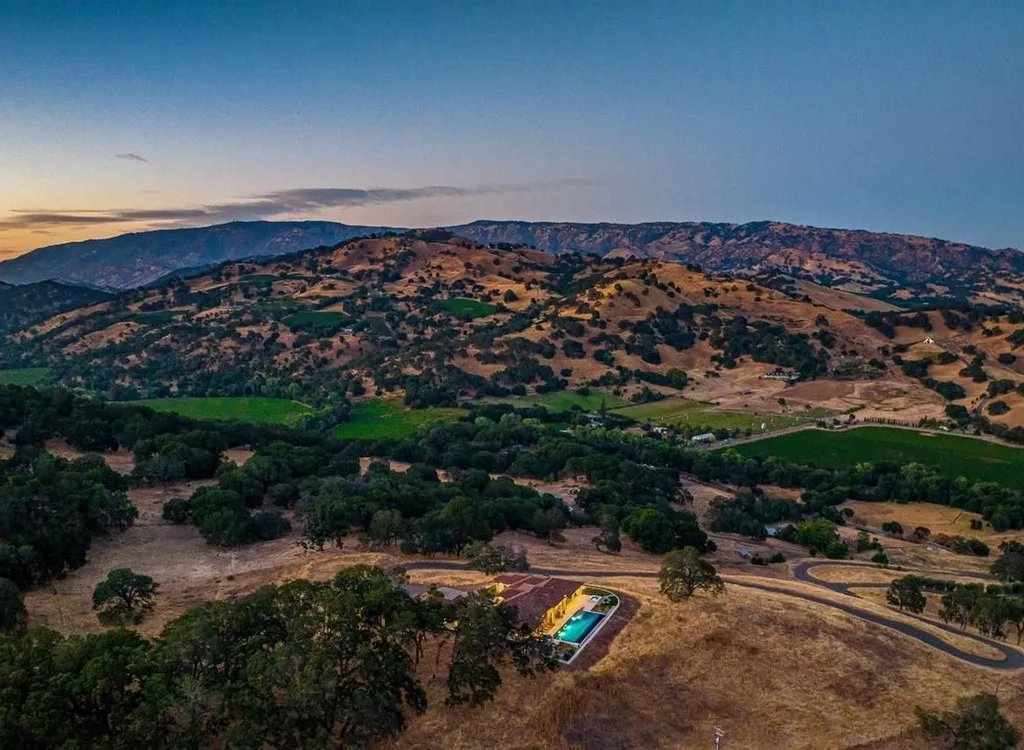 5343-5355 Suisun Valley Road Home in Fairfield, California. Stunning 20-acre hilltop compound in Fairfield boasts panoramic views of the valley, vineyards, and Mount Diablo. The Tuscan-inspired main house features cathedral ceilings, antique beams, and travertine flooring. The majestic living/dining great room has a fireplace and overlooks the pool, patio, and views. 