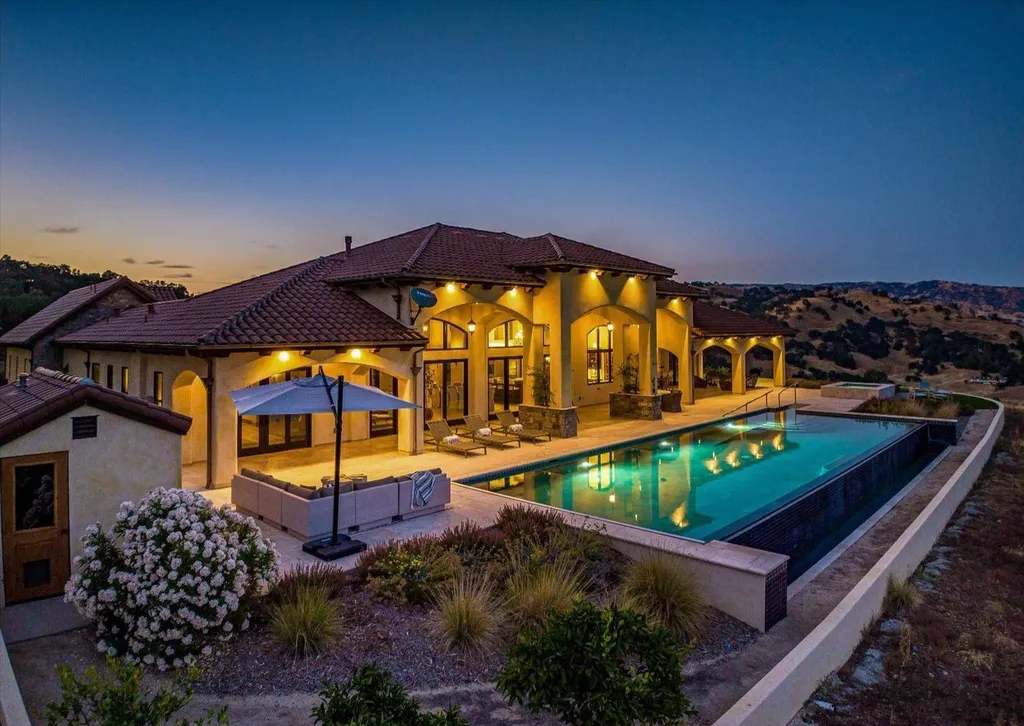 5343-5355 Suisun Valley Road Home in Fairfield, California. Stunning 20-acre hilltop compound in Fairfield boasts panoramic views of the valley, vineyards, and Mount Diablo. The Tuscan-inspired main house features cathedral ceilings, antique beams, and travertine flooring. The majestic living/dining great room has a fireplace and overlooks the pool, patio, and views. 
