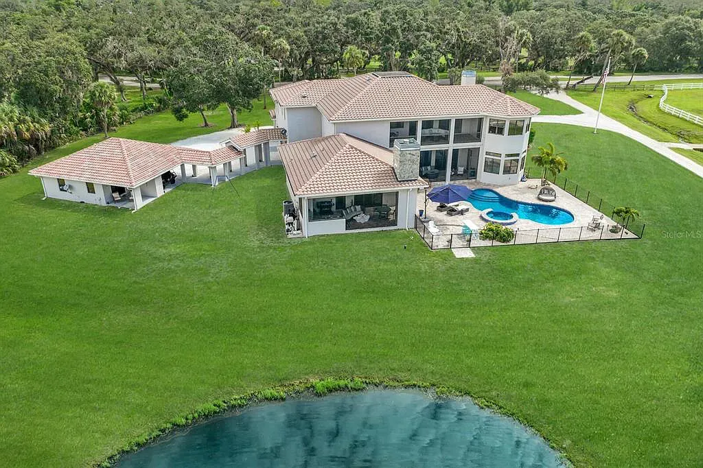 5952 Vanderipe Road Home in Sarasota, Florida. Discover luxurious country living at its finest in this custom-designed home nestled on a sprawling equestrian estate in Myakka Valley Ranches. With over 12 acres of land, two separate lots, and a meticulously crafted residence boasting modern amenities, this property offers a canvas for your dreams to flourish.