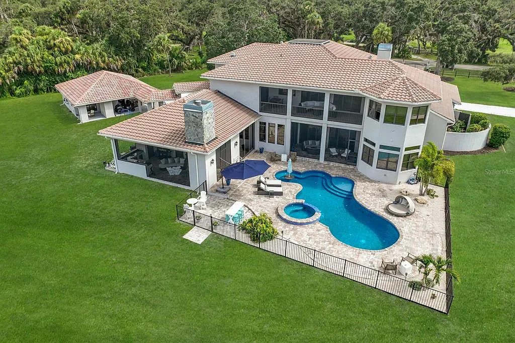 5952 Vanderipe Road Home in Sarasota, Florida. Discover luxurious country living at its finest in this custom-designed home nestled on a sprawling equestrian estate in Myakka Valley Ranches. With over 12 acres of land, two separate lots, and a meticulously crafted residence boasting modern amenities, this property offers a canvas for your dreams to flourish.
